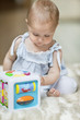 Baby girl playing with a musical block toy