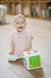 Baby girl playing with a musical block toy