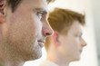 Close-up of a man with another man in the background