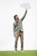 Man holding a thought bubble in a field