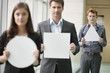 Business executives holding geometrical shaped placards in an office