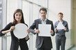 Business executives holding blank placards in an office