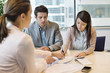 Couple signing documents with business executive