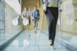 Disabled woman walking with a man and a woman running behind her