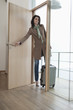 Woman closing the door of a house