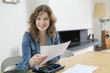Portrait of a woman sorting out bills
