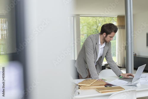 Photo: Interior designer working on a laptop in the office Interior designer working on a laptop in the office