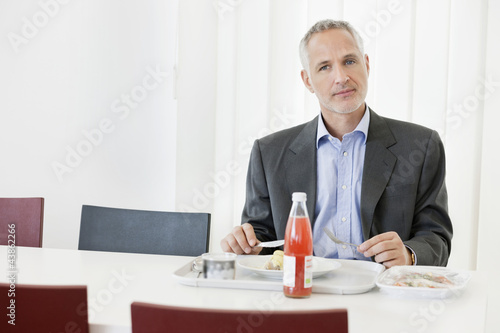 Photo: Businessman having lunch in the office Businessman having lunch in the office