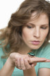 Woman looking at a beetle on her hand