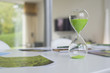 Green hourglass and ecological poster on a table