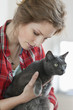 Close-up of a woman holding a black cat