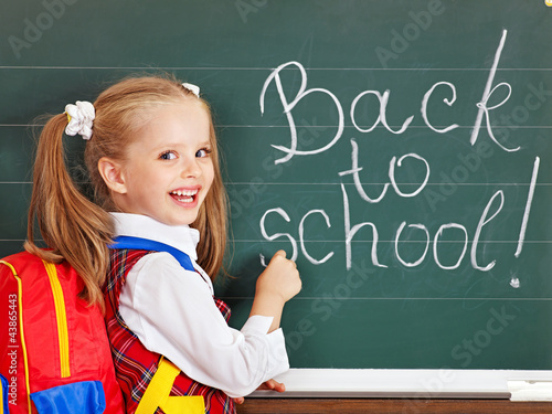 Photo: Schoolchild writting on blackboard. Schoolchild writting on blackboard.