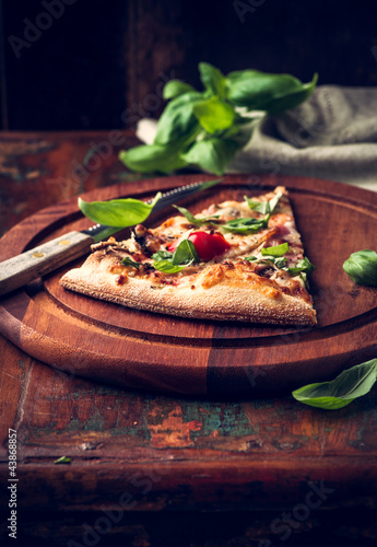 Photo: Slice of rustic pizza topped with fresh basil Slice of rustic pizza topped with fresh basil