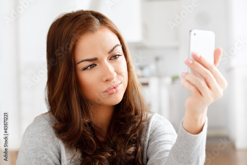 Photo: Pretty young woman using mobile phone Pretty young woman using mobile phone
