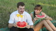 Young couple eating watermelon at picnic