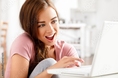 Foto: attractive young teenager surfing the internet attractive young teenager surfing the internet