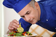 Chef garnishing salad dish with care and attention