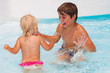 Foto: Little baby girl with her brother swimming in the pool Little baby girl with her brother swimming in the pool