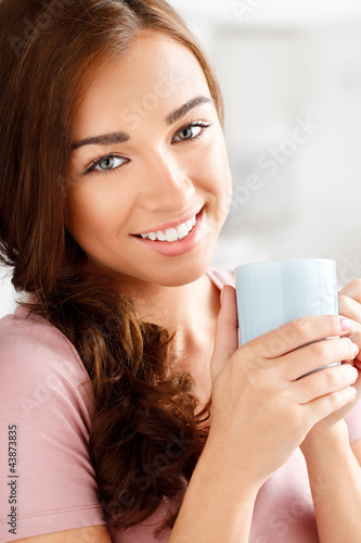 Foto: attractive young woman drinking coffee at home attractive young woman drinking coffee at home