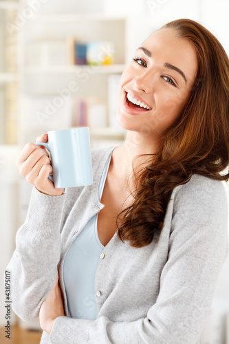 Photo: attractive young woman drinking coffee at home attractive young woman drinking coffee at home