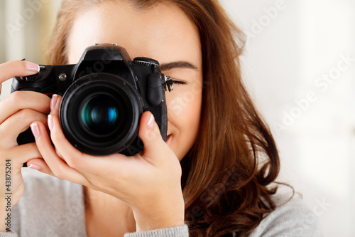 Photo: Pretty woman is a proffessional photographer with dslr camera Pretty woman is a proffessional photographer with dslr camera