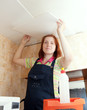 Woman glues ceiling tile
