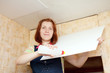 woman glues ceiling tile at home
