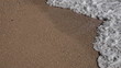 Sand beach with sea foam