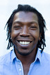 Close up portrait of a black Jamaican man with dreadlocks.