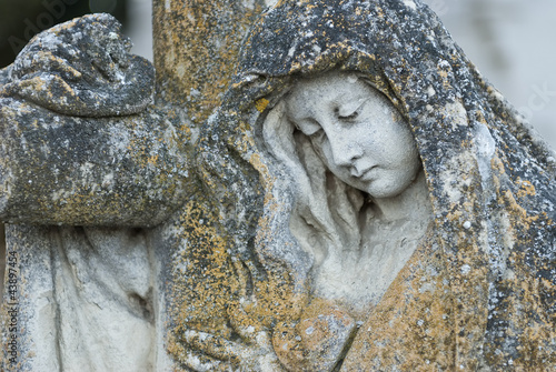 Foto: Estatua de una mujer agarrada a una cruz en un cementerio. Estatua de una mujer agarrada a una cruz en un cementerio.