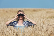 frau mit fernglas im kornfeld