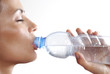 Mujer bebiendo una botella de agua mineral.
