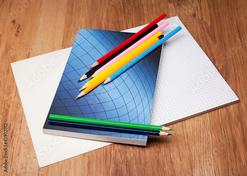 Photo: pencils and notebook on wooden table pencils and notebook on wooden table