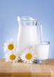Photo: Jug fresh milk, Glass and three chamomile flowers is wooden tabl Jug fresh milk, Glass and three chamomile flowers is wooden tabl