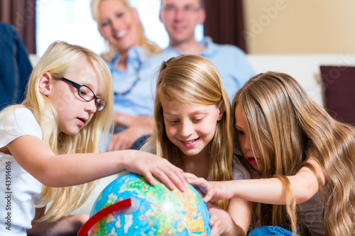 Foto: Family at home, the children playing with a globe Family at home, the children playing with a globe