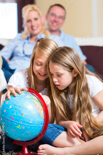Photo: Family at home, the children playing with a globe Family at home, the children playing with a globe