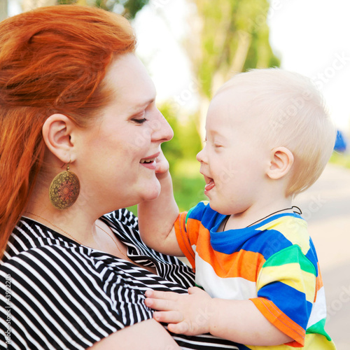Photo: mother and baby with Down syndrome smiling, hugging and talking mother and baby with Down syndrome smiling, hugging and talking