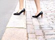Photo: Female stepping onto the sidewalk in a street Female stepping onto the sidewalk in a street
