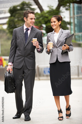 Photo: Businessman And Businesswoman Walking Along Street With Coffee Businessman And Businesswoman Walking Along Street With Coffee