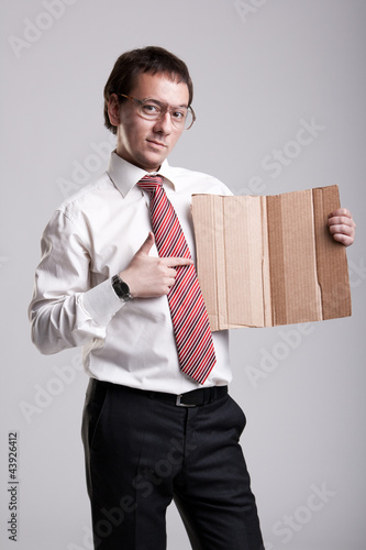 Photo: Nerdy businessman holding a cardboard Nerdy businessman holding a cardboard
