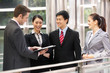 Photo: Four Business Colleagues Discussing Document Outside Office Four Business Colleagues Discussing Document Outside Office