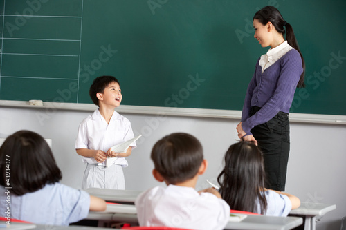 Photo: Pupil And Teacher Standing By Blackboard In Chinese Classroom Pupil And Teacher Standing By Blackboard In Chinese Classroom