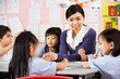 Photo: Teacher Helping Students During Art Class In Chinese School Teacher Helping Students During Art Class In Chinese School