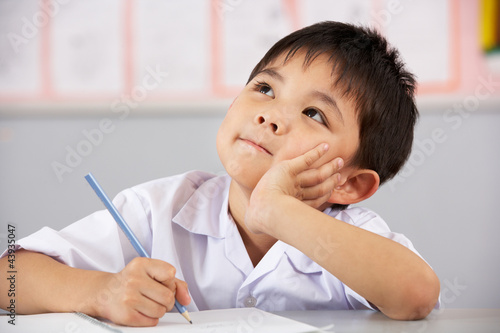 Photo: Male Student Working At Desk In Chinese School Classroom Male Student Working At Desk In Chinese School Classroom