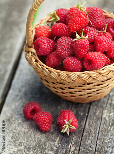 Photo: fresh raspberry in a basket on wooden table fresh raspberry in a basket on wooden table
