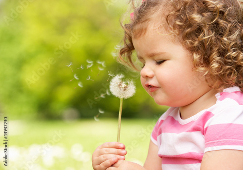 Photo: Young Girl In Summer Dress Sitting In Field Blowing Dandelion Young Girl In Summer Dress Sitting In Field Blowing Dandelion