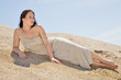 Beautiful brunette  layed down on the sand