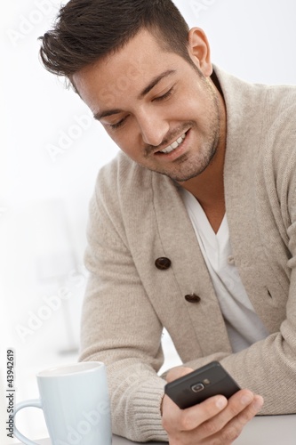 Photo: Portrait of young man with mobile phone Portrait of young man with mobile phone