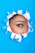 Female face through the hole in paper
