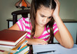 Angry and tired schoolgirl studying at home